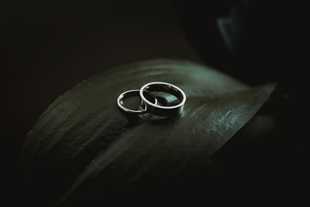 Silver and gold wedding band rings on dark background